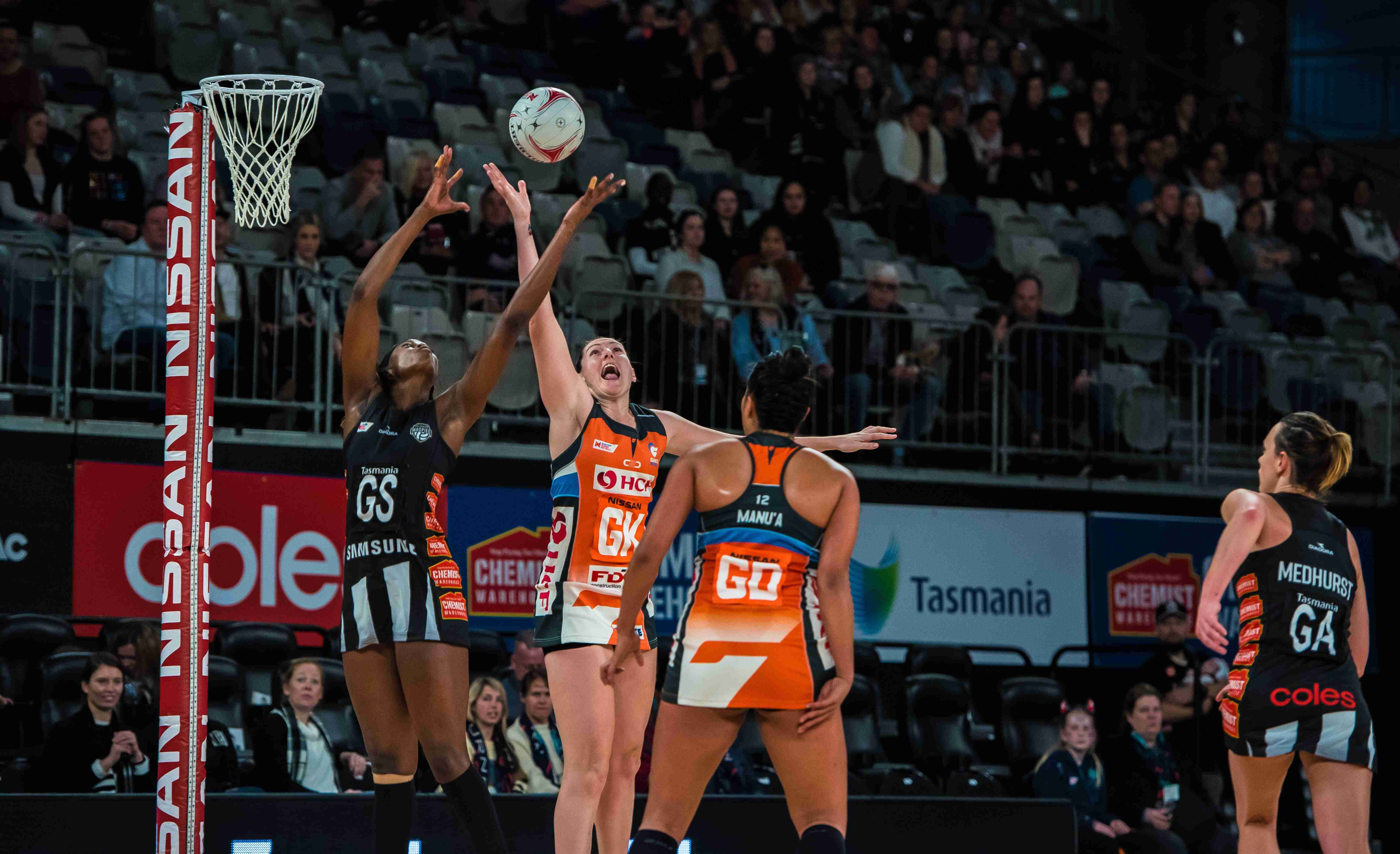 action shot of netball team blocking a pass between players